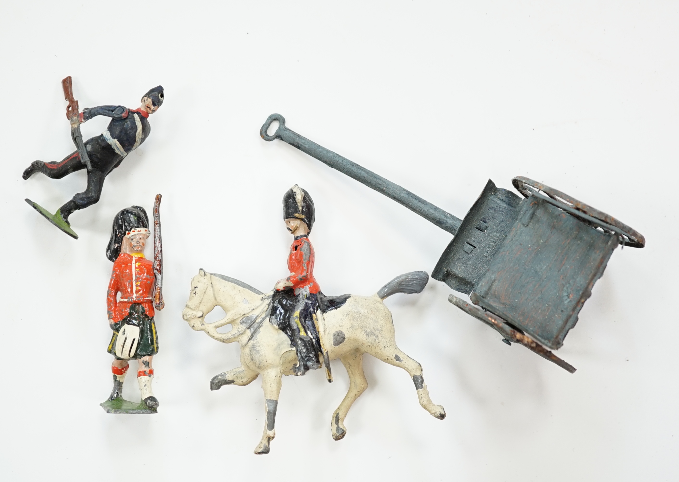 Forty-four early twentieth century Britains, etc. cavalry and infantry soldiers including; Scots Guards, mounted Grenadier Guards, bandsmen, etc. together with a field gun and tinplate lumber